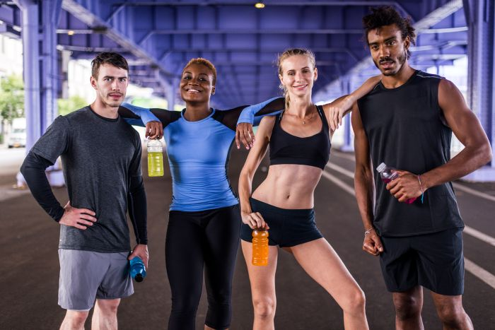 Four people standing together wearing sportswear